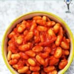 A green bowl full of homemade baked beans