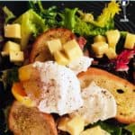 A salad with croutons, cheese and poached eggs.
