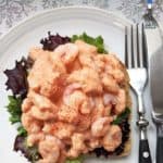 A prawn marie rose open sandwich on a white plate