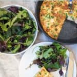 A pan with frittata, a bowl of salad and a plate with frittata and salad