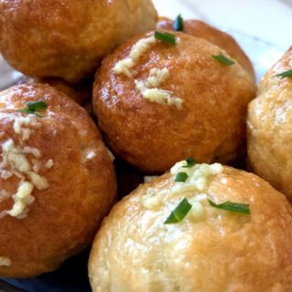 A pile of garlic topped dough balls.
