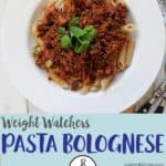 A white bowl of pasta topped with Bolognese sauce