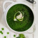 A white bowl full of spinach and pea soup
