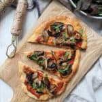 A mushroom pizza on a wooden board