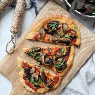 A mushroom pizza on a wooden board