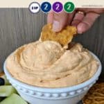 A cookie being dipped into pumpkin fluff