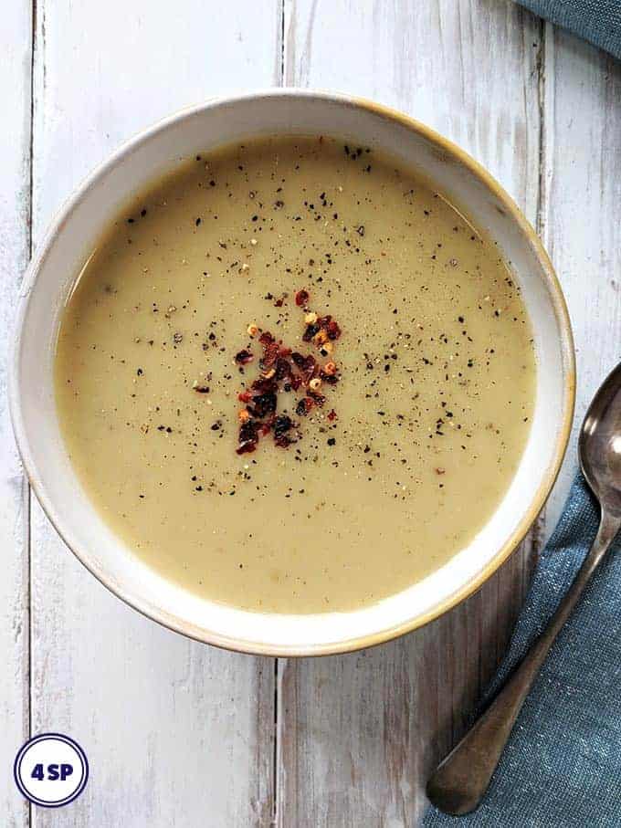 A bowl of Spiced Parsnip Soup on a white table