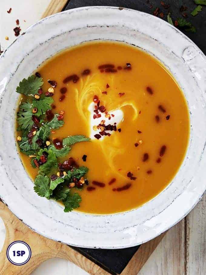 A white bowl filled with thai spiced butternut squash soup