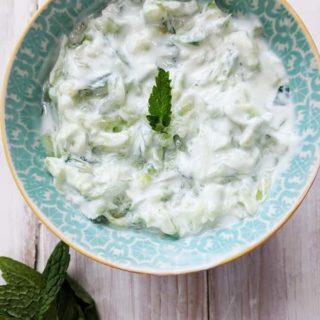 A bowl of Tzatziki on a white table