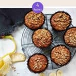 Banana Muffins on a wire rack with a peeled banana along side