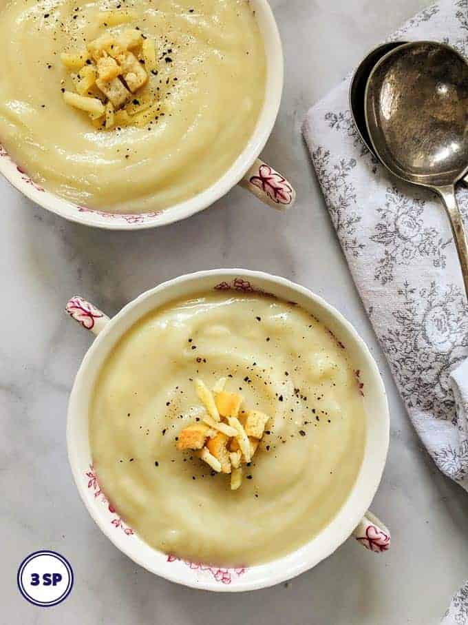 Two bowls of cauliflower cheese soup