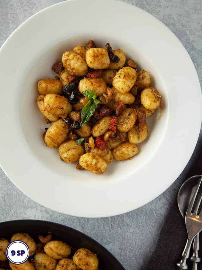 A white bowl of gnocchi pesto