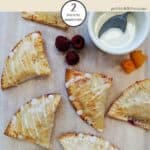 A tray of peach pies with peach and raspberries