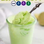 A jar of bright green dessert in a jar with a spoon