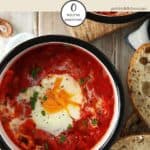 A dish of shakshuka on a white wooden table