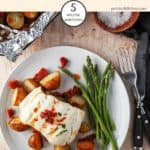 Baked cod & chorizo on a plate with new potatoes and asparagus