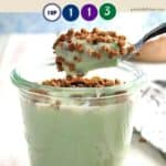 A glass jar full of pistachio pudding with a spoon