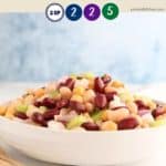 A white china bowl full of bean salad