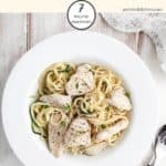 A bowl of chicken Alfredo on a white table