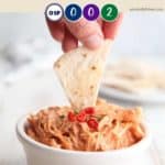 A tortilla chip dipped in buffalo chicken dip