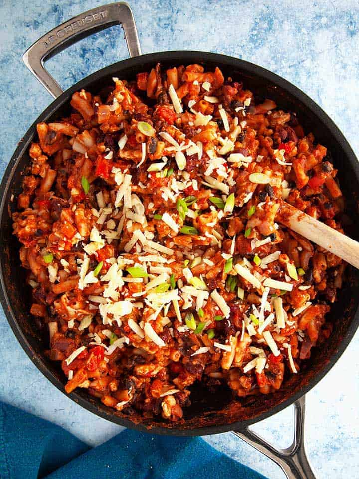 A skillet of chili on a blue table