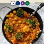 A dish of chickpea curry on a white background