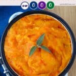 A dish of mashed carrots and rutabaga on a blue background