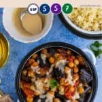 A dish of vegan eggplant and chickpea stew on a blue background