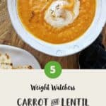 A bowl of carrot and lentil soup on a wooden table