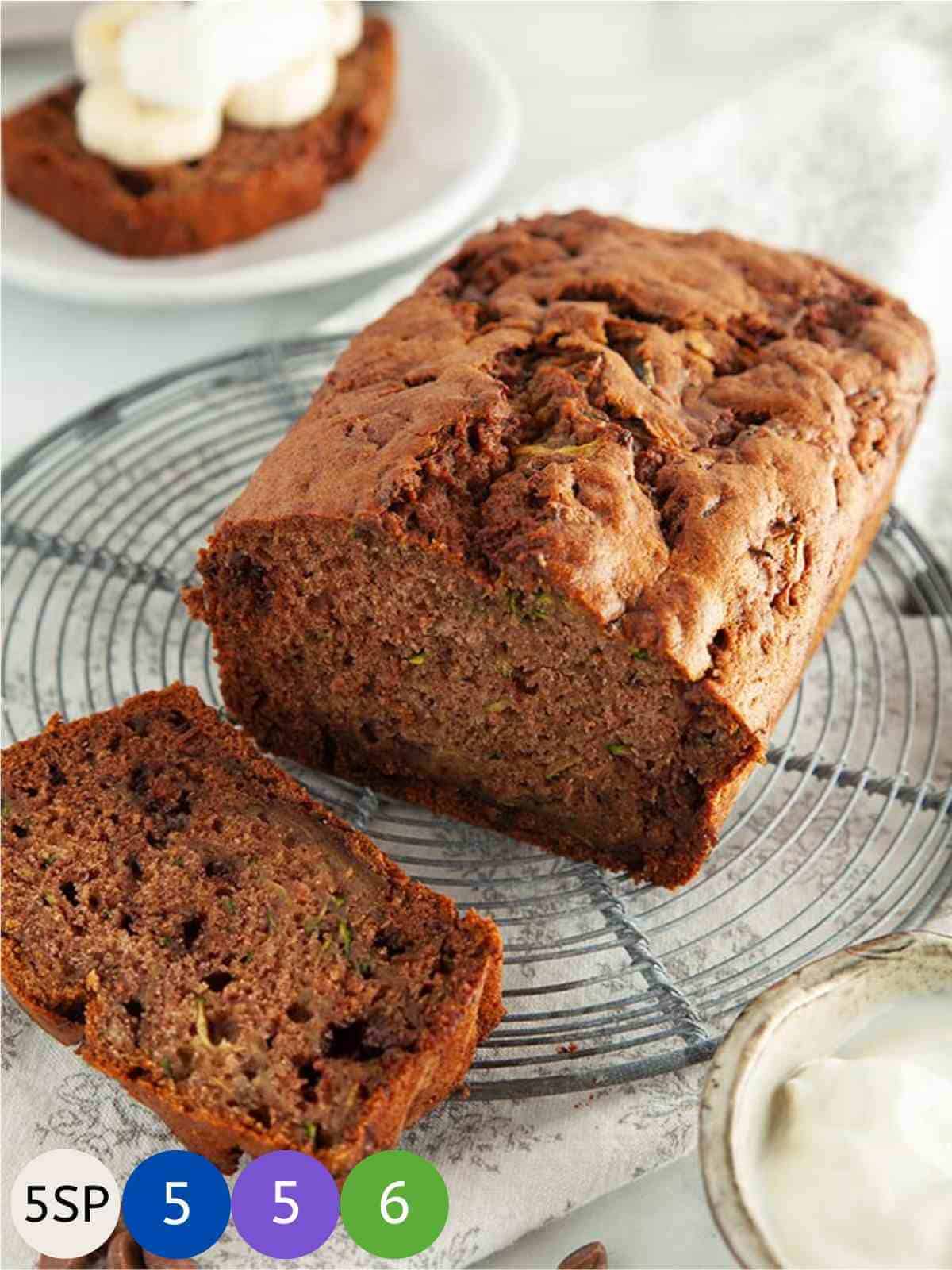 A chocolate chip zucchini bread loaf on a circular metal cooling rack