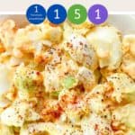 A close up picture of egg salad in a white bowl