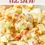 A white bowl of egg salad with paprika sprinkled on top