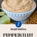 A white bowl full of pink coloured pumpkin fluff with a cookie being dipped in.