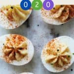 A marble table with 6 deviled eggs dusted with paprika and chives with text overlay stating Weight Watchers Deviled Eggs.