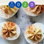 A marble table with 6 deviled eggs dusted with paprika and chives with text overlay stating Weight Watchers Deviled Eggs.