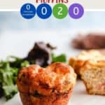 A breakfast muffin on a white plate with some lettuce in the background.