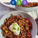 A bowl of burrito mixture topped with yogurt and chopped spring onion on a white table & text overlay 'Weight Watchers Burrito Bowl'.