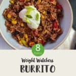 A bowl of burrito mixture topped with yogurt and chopped spring onion on a white table & text overlay 'Weight Watchers Burrito Bowl'.