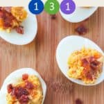 5 cheese and bacon stuffed eggs on a wooden board.