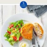 A white plate with a fishcake and some salad on a white wooden table with text overlay 'Weight Watchers Tuna Fish Cakes'.