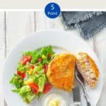 A white plate with a fishcake and some salad on a white wooden table with text overlay 'Weight Watchers Tuna Fish Cakes'.