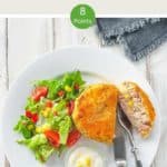 A white plate with a fishcake and some salad on a white wooden table with text overlay 'Weight Watchers Tuna Fish Cakes'.