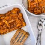 A dish of french toast casserole with a wooden spatula.