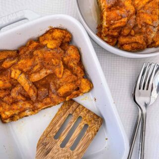 A dish of french toast casserole with a wooden spatula.