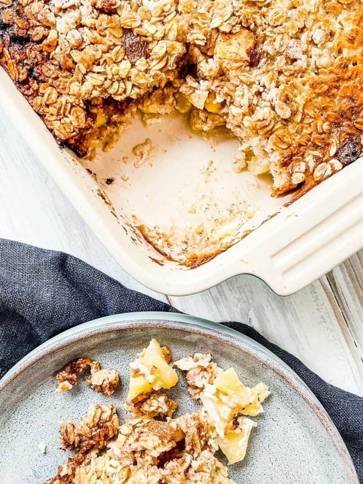 A dish of baked oatmeal with apples on a white table.
