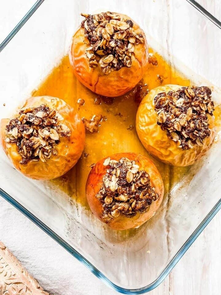 A glass baking dish with 4 baked apples.